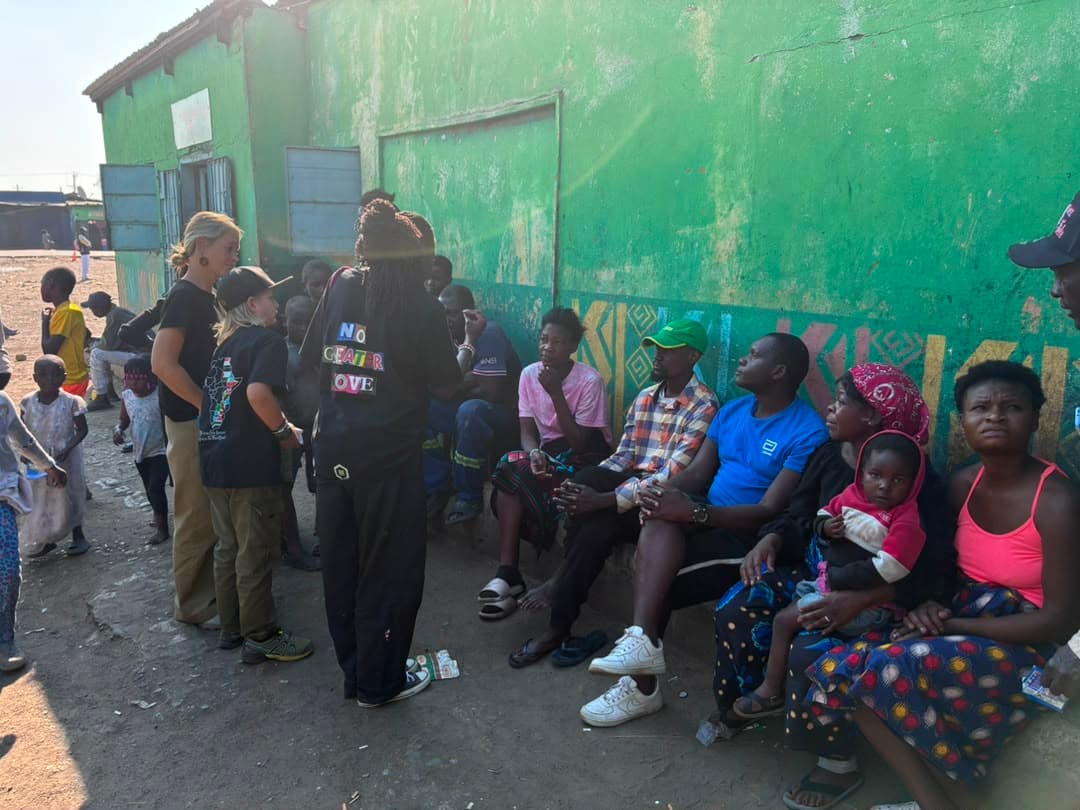 YWAM Kona and Kubamba team members speaking with families during street evangelism